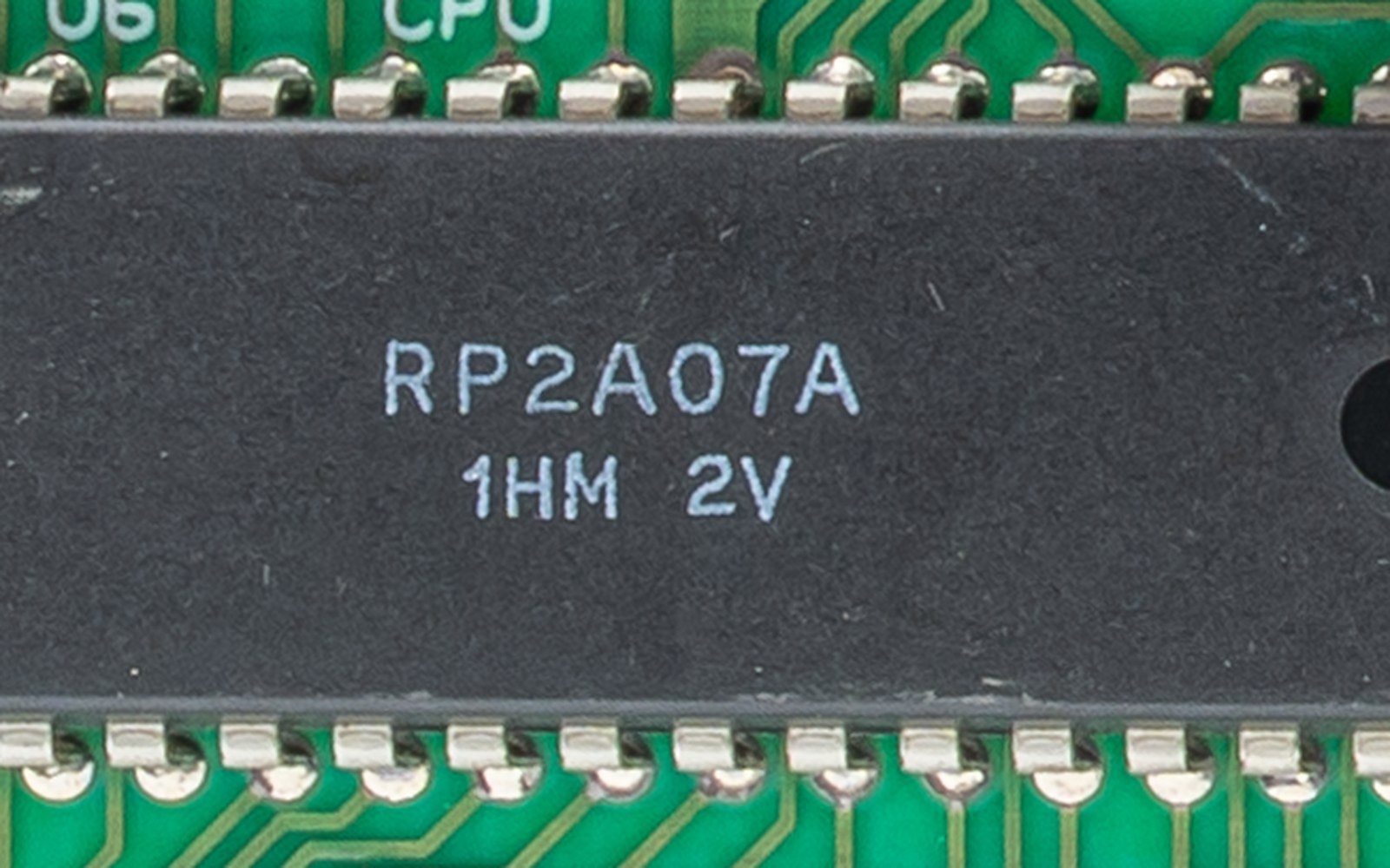Close-up of an RP2A07A chip labeled 1HM 2V mounted on a green circuit board