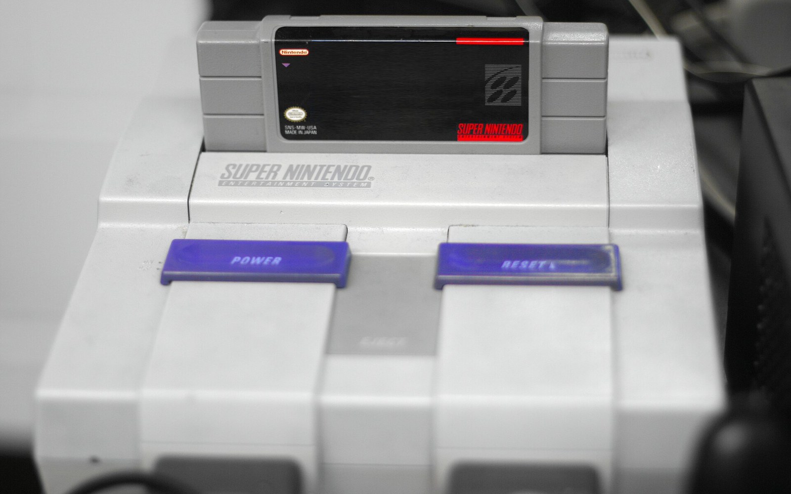 A game cartridge inserted into a Super Nintendo Entertainment System console