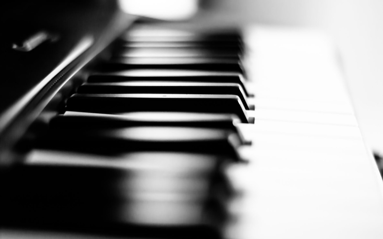 Close-up of piano keys in black and white, shot at a low angle