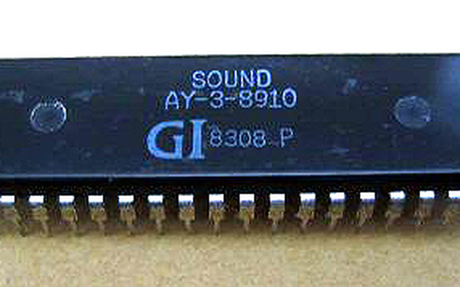 Close-up of a black GI AY-3-8910 sound chip showing its printed label and metal pins